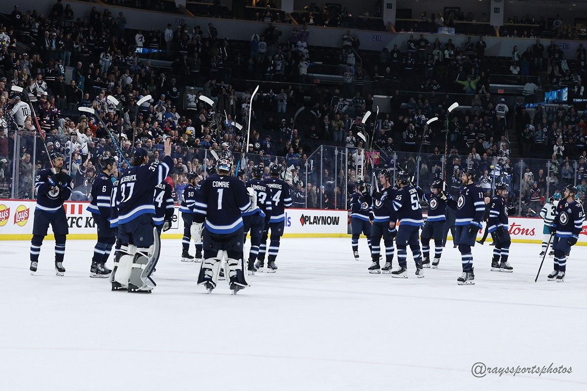 All players from the Winnipeg Jets skate at centre ice with sticks in air following the end of a game